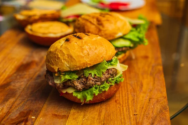 Tahta tahtada iki ev yapımı ızgara hamburger. Ev yapımı hamburgerler. Ev yapımı yemekler.
