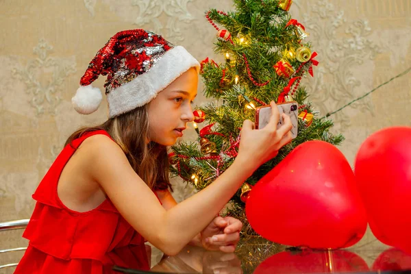 Menina Adolescente Bonita Segura Smartphone Suas Mãos Frente Árvore Natal — Fotografia de Stock