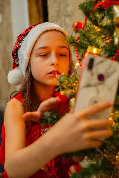 Menina Adolescente Bonita Segura Smartphone Suas Mãos Frente Árvore Natal — Fotografia de Stock