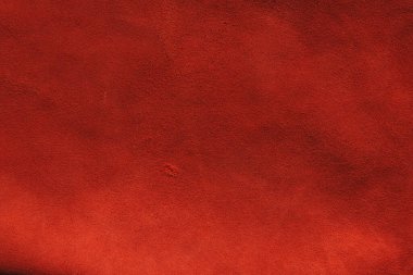 Süet kumaşın kırmızı mat arka planı, yakın plan. Pürüzsüz deri kadife desenli. Keçeleşmiş makro. Kırmızı süet kumaş. Kumaş, deri, tasarımcılar için malzeme..