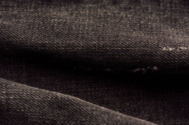 Siyah Denim kumaş dokusu. Soyut arkaplan tasarımı için kot veya siyah kot kumaş desenli. Arka plan dokusu olarak siyah kot pantolon kumaş parçası