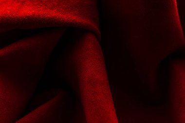 Süet kumaşın kırmızı mat arka planı, yakın plan. Pürüzsüz deri kadife desenli. Keçeleşmiş makro. Kırmızı süet kumaş. Kumaş, deri, tasarımcılar için malzeme..