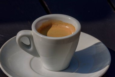 Tahta Masa 'da kahve kupası. Bir fincan sıcak espresso kahvesi, Arabica 'dan mayalanmış, doku arka planında. Tahta Masada Beyaz Seramik Kupada Siyah Kahve