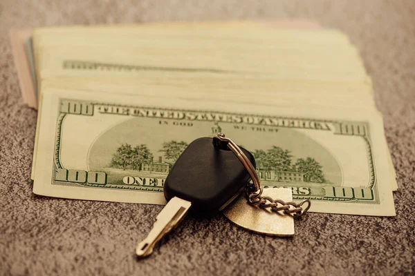 A set of car keys with cash, car payment. Car keys and dollars. Key from the car and money