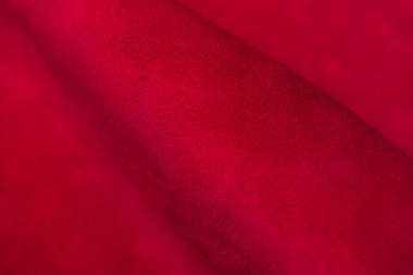 Süet kumaşın kırmızı mat arka planı, yakın plan. Pürüzsüz deri kadife desenli. Keçeleşmiş makro. Kırmızı süet kumaş. Kumaş, deri, tasarımcılar için malzeme..