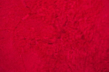 Süet kumaşın kırmızı mat arka planı, yakın plan. Pürüzsüz deri kadife desenli. Keçeleşmiş makro. Kırmızı süet kumaş. Kumaş, deri, tasarımcılar için malzeme..