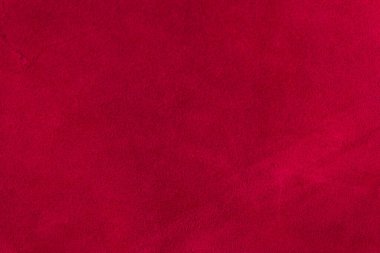 Süet kumaşın kırmızı mat arka planı, yakın plan. Pürüzsüz deri kadife desenli. Keçeleşmiş makro. Kırmızı süet kumaş. Kumaş, deri, tasarımcılar için malzeme..
