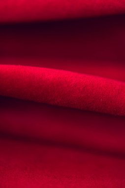 Süet kumaşın kırmızı mat arka planı, yakın plan. Pürüzsüz deri kadife desenli. Keçeleşmiş makro. Kırmızı süet kumaş. Kumaş, deri, tasarımcılar için malzeme..