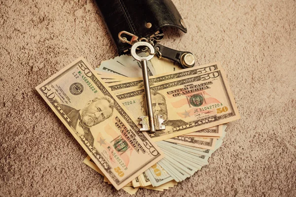 Keys and money. Dollars and apartment keys. dollars on which are the keys to the apartment. the concept of saving and buying an apartment
