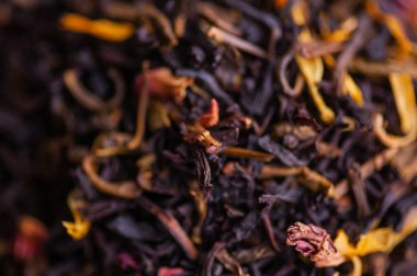 Yeşil çay ve gül. Tadı siyah, kurutulmuş çay karışımı ve gül yaprakları. Siyah ve yeşil çay karışımı. Yanında da çiçek çiçeği ve gül yaprakları. kuru çay yaprakları