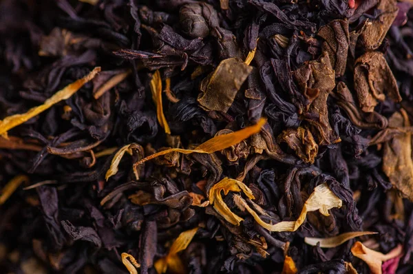 Green tea with a rose. Flavored black, dried tea mix with rose petals. a mixture of black and green tea with the addition of cornflower and tea rose petals. dry tea leaves