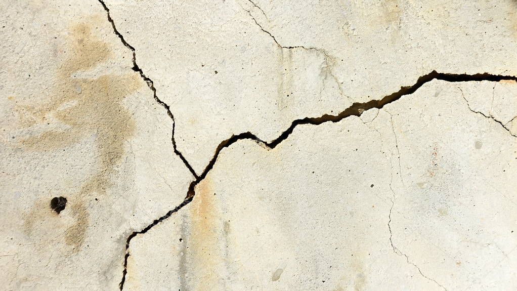 A crack on the concrete wall surface of a house in Los Angeles. Background image for design