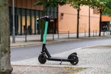 Berlin, Almanya-Temmuz 07, 2019: bir yeşil e scooter altında Park 