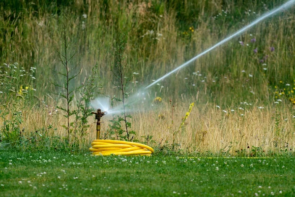 Vattna gräsmattan på sommaren — Stockfoto
