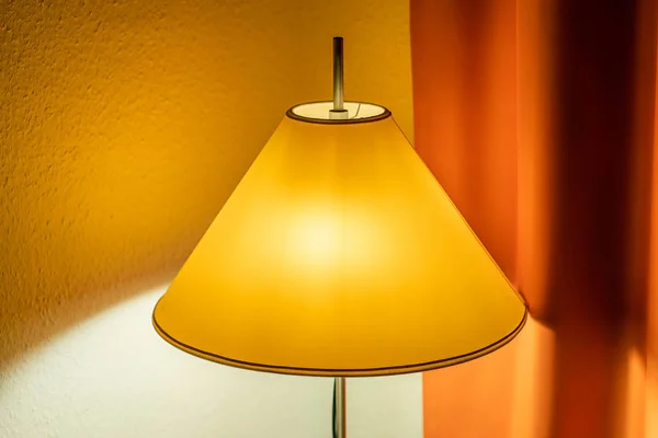 Lampe lumineuse avec une nuance jaune et un rideau orange dans la ba — Photo