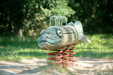 Tahta el, oyun parkında balık yumurtası sallıyor.