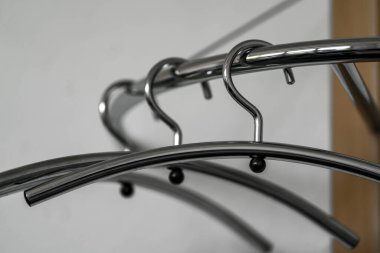 Ahşap bir askıda asılı üç krom kaplama askı.