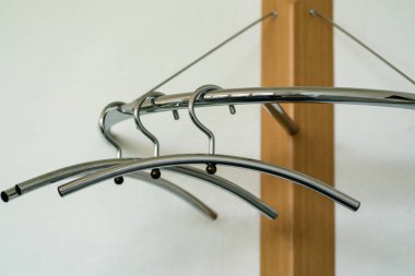 Ahşap bir askıda asılı üç krom kaplama askı.