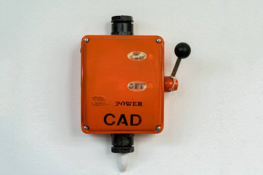 Eski bir fabrikada elektriği açıp kapatmak için kullanılan turuncu renkli yüksek gerilim anahtarı.
