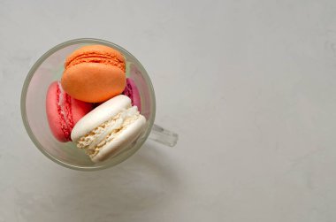 Cam bardakta çok renkli badem kurabiyeleri ve peçetede pipetle içilen içecekler. Mkaronlar ya da badem kurabiyeleri Fransız ya da İtalyan tatlısıdır. Yakın plan..