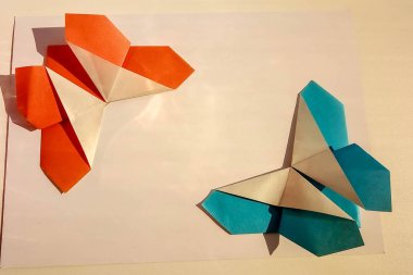 Çocuk elleri beyaz arka plan üzerinde renkli kağıt origami yok. origami dersi