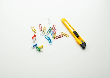 Ofisteki masada kırtasiye, kağıt üzerinde bir bıçak ve bir klip.