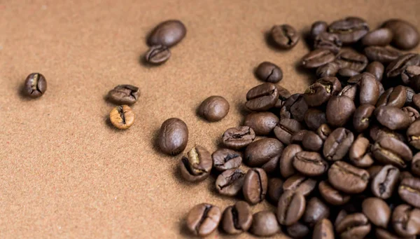 갈색의 볶은 커피 콩 이 더미 위에 떨어지고 있습니다. 아침 식사, 에너지, 신선 함 또는 향기를 제공 복사 공간으로 어두운 배경 위에 비행, 클로즈업. — 스톡 사진