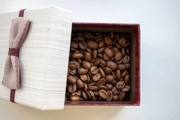 Кофейные зерна, кофейная коробка. коричневый фон — стоковое фото