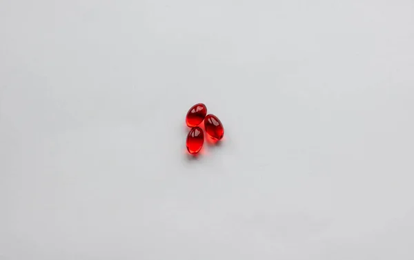 两个红色胶囊的医疗药丸被隔绝的背景 — 图库照片