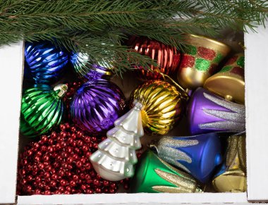 Tahta tahtaların üzerinde Noel oyuncaklarıyla dolu bir kutu. Yeni Yıl Dekorasyonu.