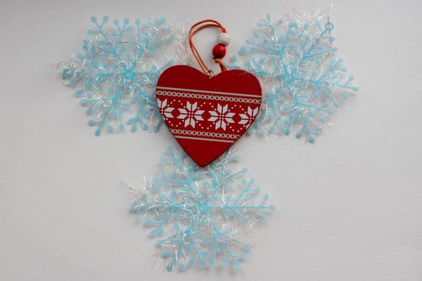 Christmas snowflakes on blue wooden background. Heart of white snowflakes — Stock Photo, Image