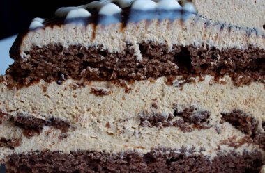 Lezzetli çikolatalı pastanın yarısı beyaz tabakta..