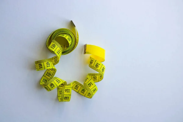 Fita métrica em centímetros como símbolo da dieta antes da hora de verão e estilo de vida saudável, ferramenta de alfaiataria no fundo branco — Fotografia de Stock