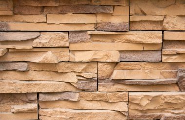 Duvarlara ve cephelere bakan taş. Duvar, kum taşı ya da tahta gibi taşa bakan dekoratiften yapılmıştır. Taşın dokusu.