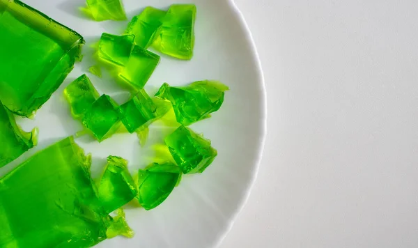 Delicious green jelly cube on white background.