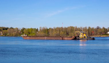 Bahar nehrinde ağır bir mavnayı iten bir römorkör..
