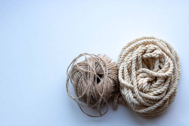 Beyaz bir arka planda iki top ip. Çamaşır ipi ve sicim..