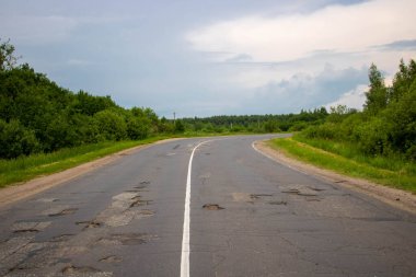 Yeşil bir ormanın ortasında kıvrımlı eski bir otoyol.