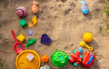 Renkli çocukların plastik oyuncakları kum havuzunda yatıyor..