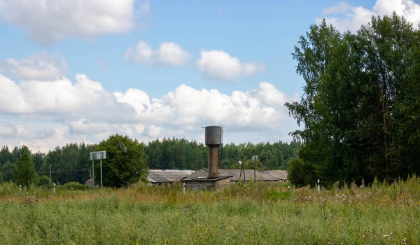 Kırsal kesimin arka planında bir su deposu var. Kule metal bir yapıdır..