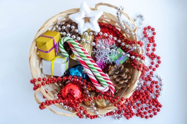 Beyaz arka planda Noel oyuncakları olan Noel sepeti
