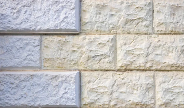 Duvarlarda beyaz ve sarı pürüzlü fayanslar. arkaplan dokusu.