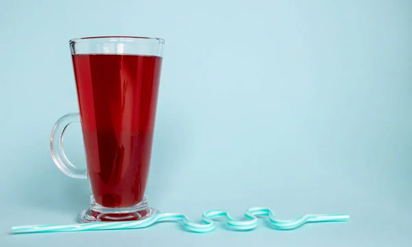 Een Glas Met Aardbeiensap Een Gebogen Buis Een Blauwe Achtergrond — Stockfoto