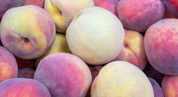 Tropikal meyve şeftalidir. Tatlı kırmızı olgun şeftalilerin dokusu. Hasat konsepti.