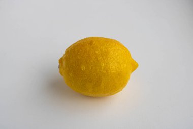 Beyaz arka planda izole edilmiş bir limon. Tropik meyve. Düz yatış, üst görünüm.
