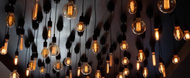 Tavanın siyah arka planında Retro Edison lambası. Kavram fikri.