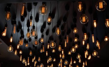 Tavanın siyah arka planında Retro Edison lambası. Kavram fikri.
