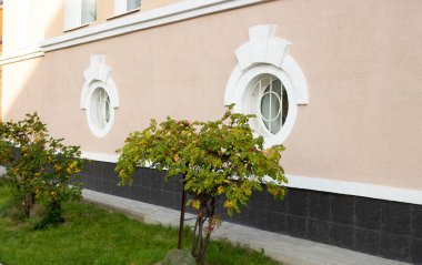 Fa kenarda. Pembe cephede yuvarlak beyaz pencereler.