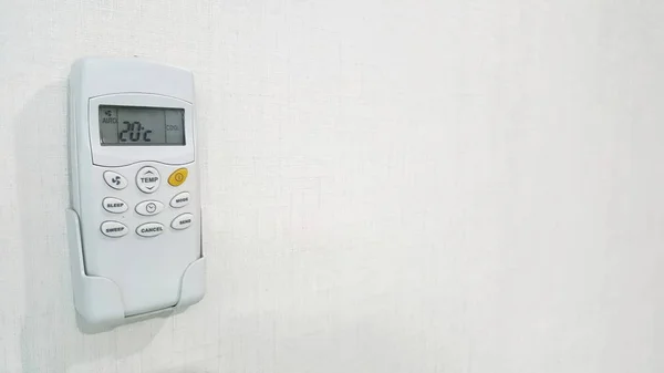 remote control air condition is set temperature at 20 celcius degree, it too cool setting and lose energy. white wallpaper.