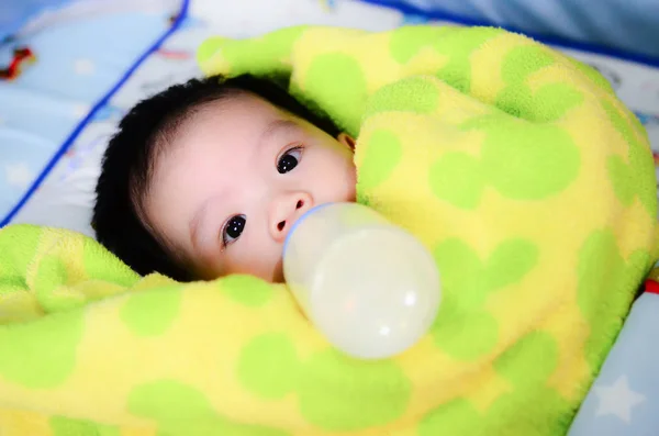 ベッドの上にボトルを供給することによってミルクを飲む幼児 — ストック写真